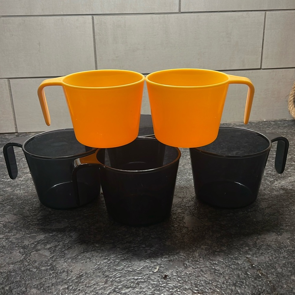 Set of 6 plastic mugs. Like new. 4 Black are smoky color and 2 golden yellow